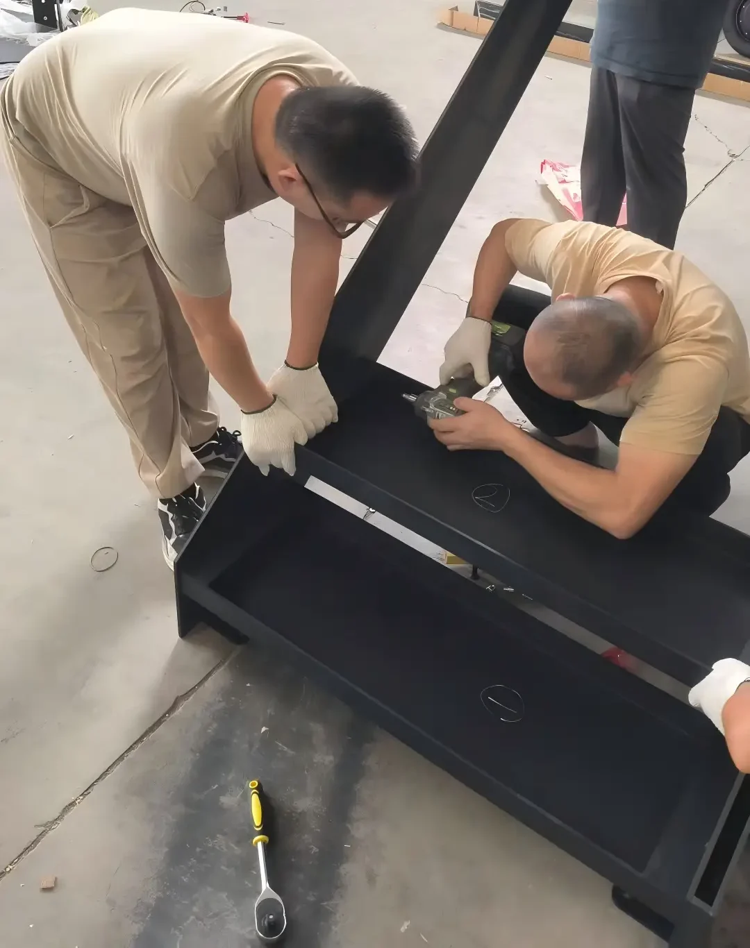 Workers pre‑assemble custom steel stringer stairs at factory workshop
