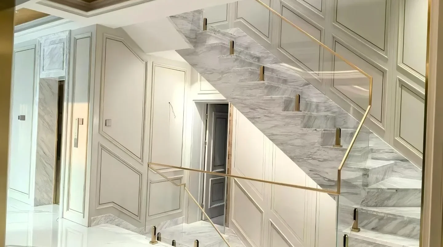 Interior luxury stair design featuring minimalist Frameless Glass Railing system with gold accents